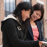 Two students reading something and smiling